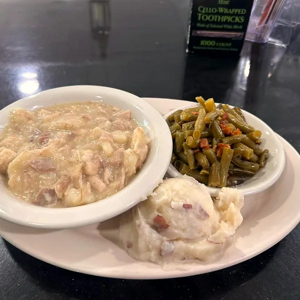 A lunch plate of creamy chicken and dumplings with mashed potatoes and green beans