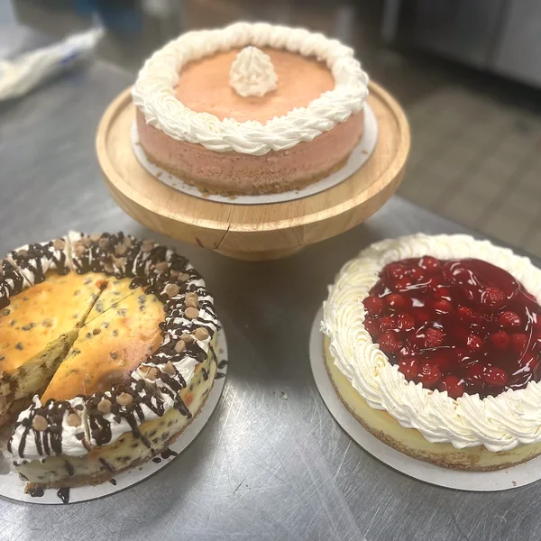 Three homemade pies and cheesecakes on a counter